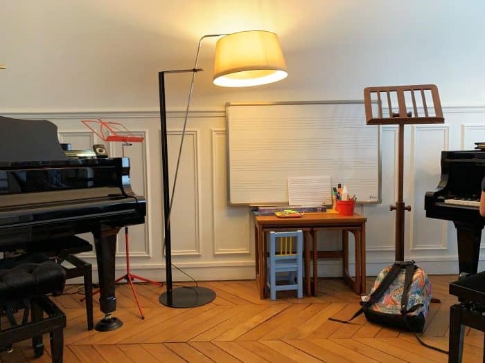 salle de cours de l'école de musique Allegria : piano, tableau blanc avec partitions, pupitre…